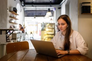 Young woman in white shirt using her laptop for online education.